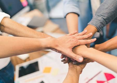 a group of employees with their hands in a pile with Business Insurance in Omaha, NE, Papillion, NE, Bellevue, NE, Treynor, IA, Council Bluffs, IA