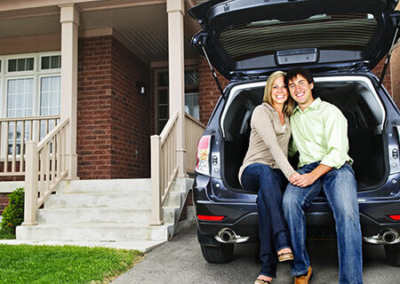 couple sitting in their car with home and auto insurance bundle